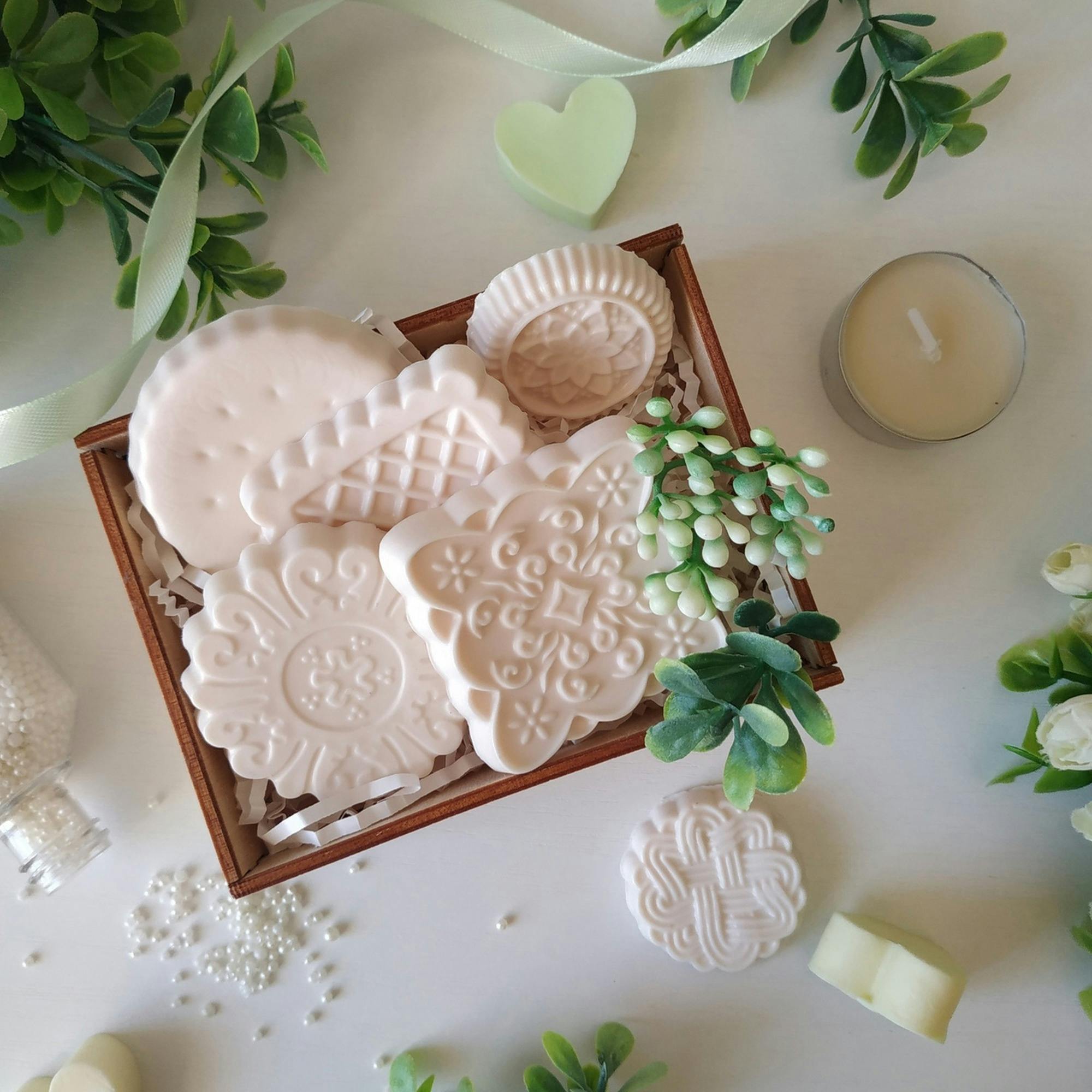 Decorative flower-shaped and shell-shaped guest soaps in a wooden tray