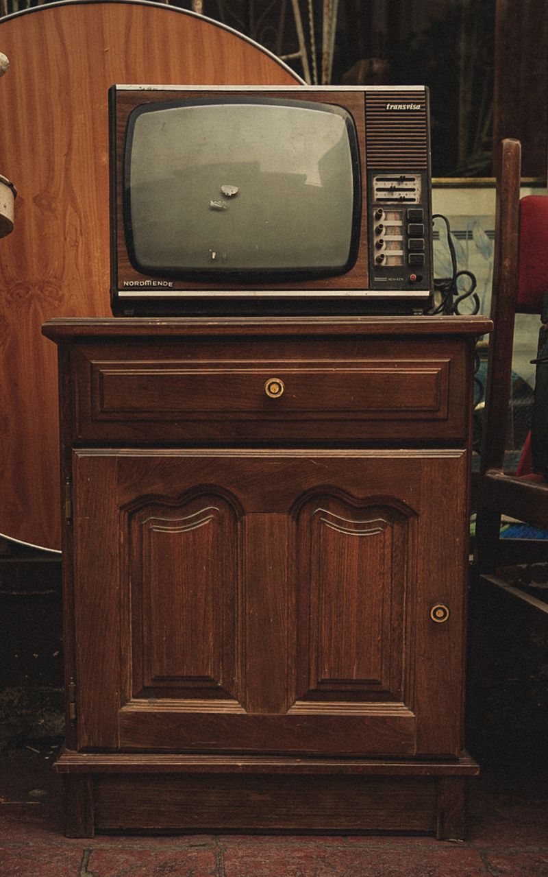 A retro television set on an antique wooden cabinet